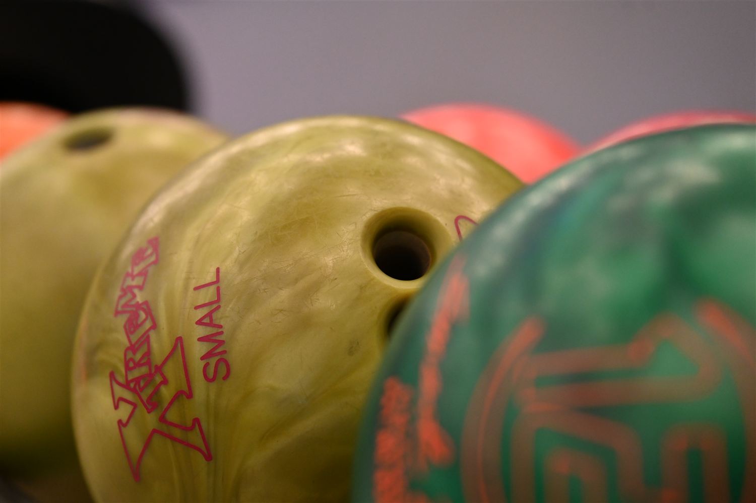 Bunte Bowlingkugeln im Kugelständer, dicht nebeneinander